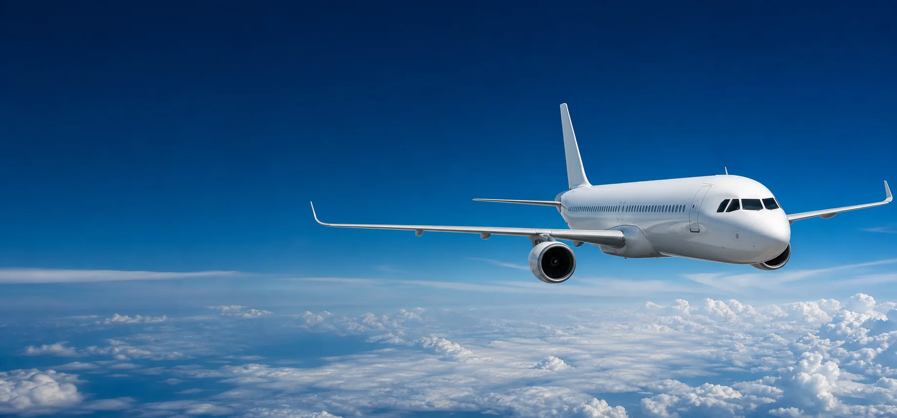 Passenger aircraft flying above clouds in a blue sky